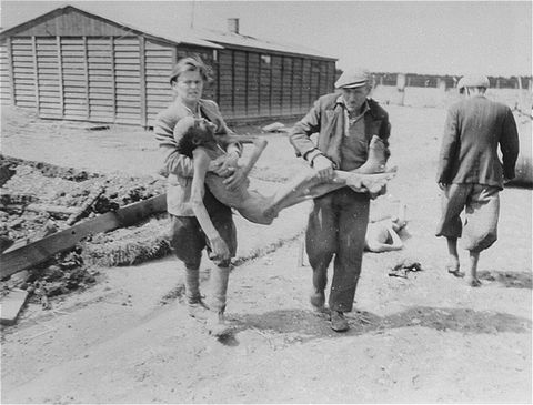 German civilians from the town of Hurlach are forced to carry corpses to mass graves for burial